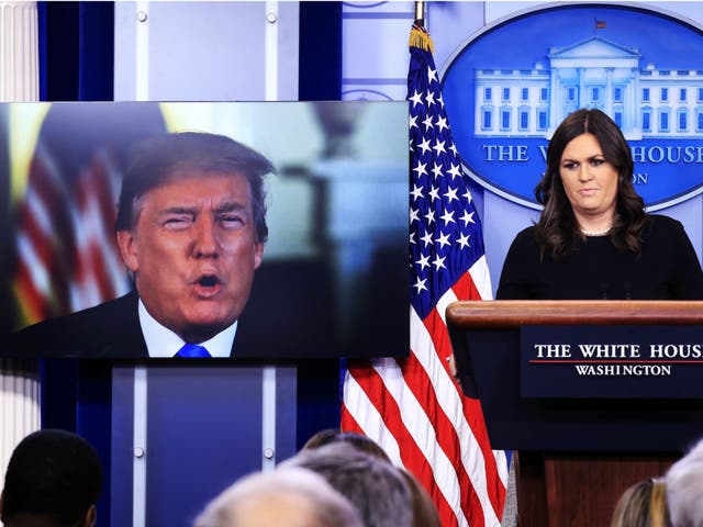 Donald Trump speaks via a video monitor to journalists during the daily White House press briefing with press secretary Sarah Huckabee Sanders