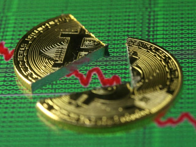 Broken representation of the Bitcoin virtual currency, placed on a monitor that displays stock graph and binary codes, are seen in this illustration picture, December 21, 2017