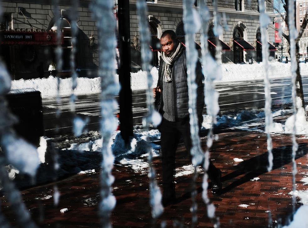 A man is reflected in a frozen window the morning after a massive winter storm in Boston