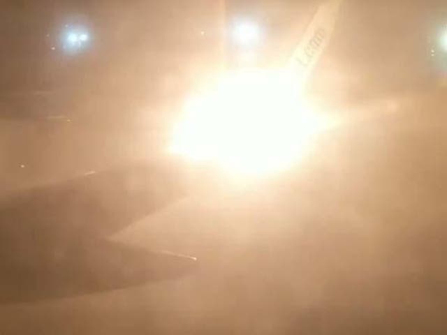 Flames on the wing of a Sunwing jet are seen through the window of another plane