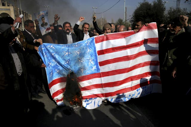 Pro-government demonstrators burn a homemade US flag during a rally following a prayer ceremony in Tehran on 5 January