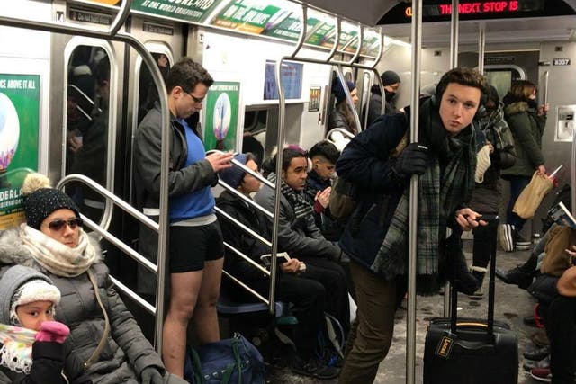 A man rides the subway in New York without trousers for the No Pants Subway Ride