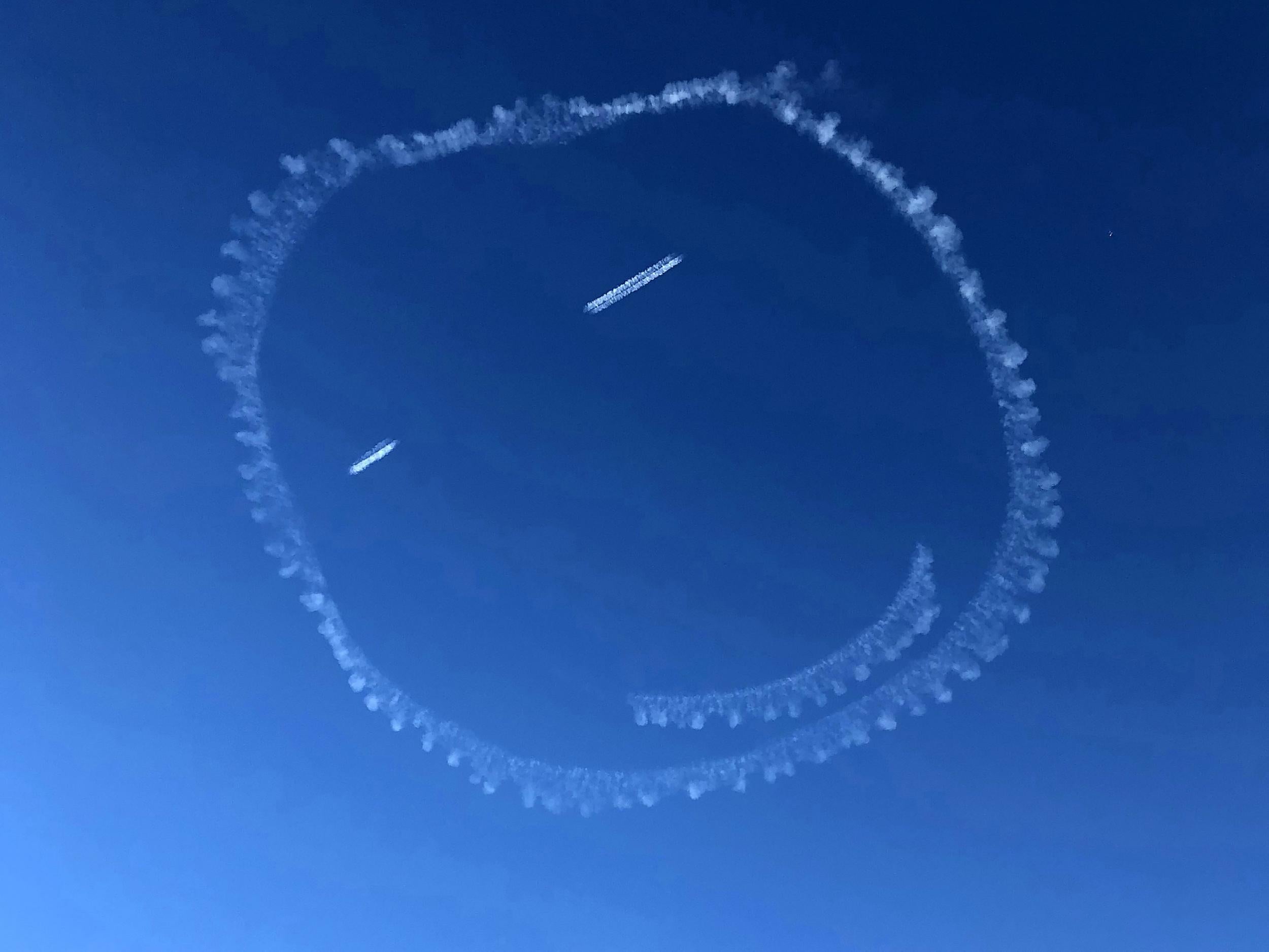 A pilot was on cloud nine when he drew this giant smiley face in the sky - using vapour from his plane's exhaust