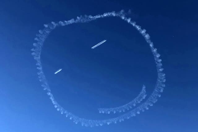 A pilot was on cloud nine when he drew this giant smiley face in the sky - using vapour from his plane's exhaust