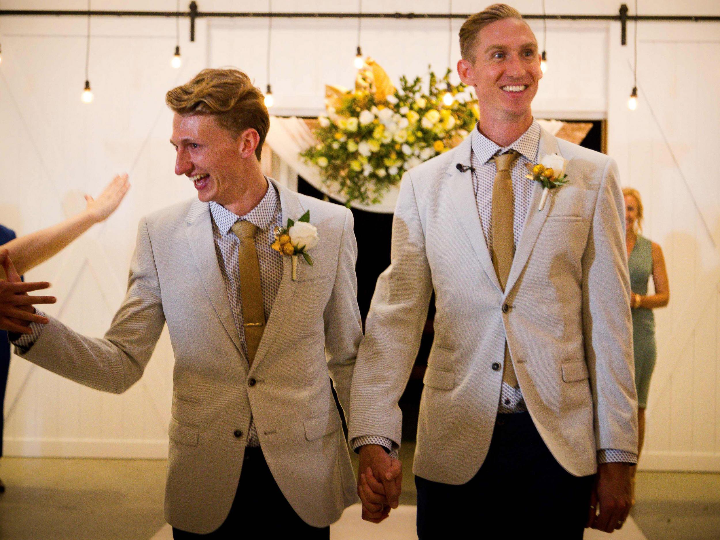 Australian Commonwealth Games sprinter Craig Burns (right) and fiance Luke Sullivan are congratulated by friends after exchanging vows at their marriage ceremony at Summergrove Estate, New South Wales