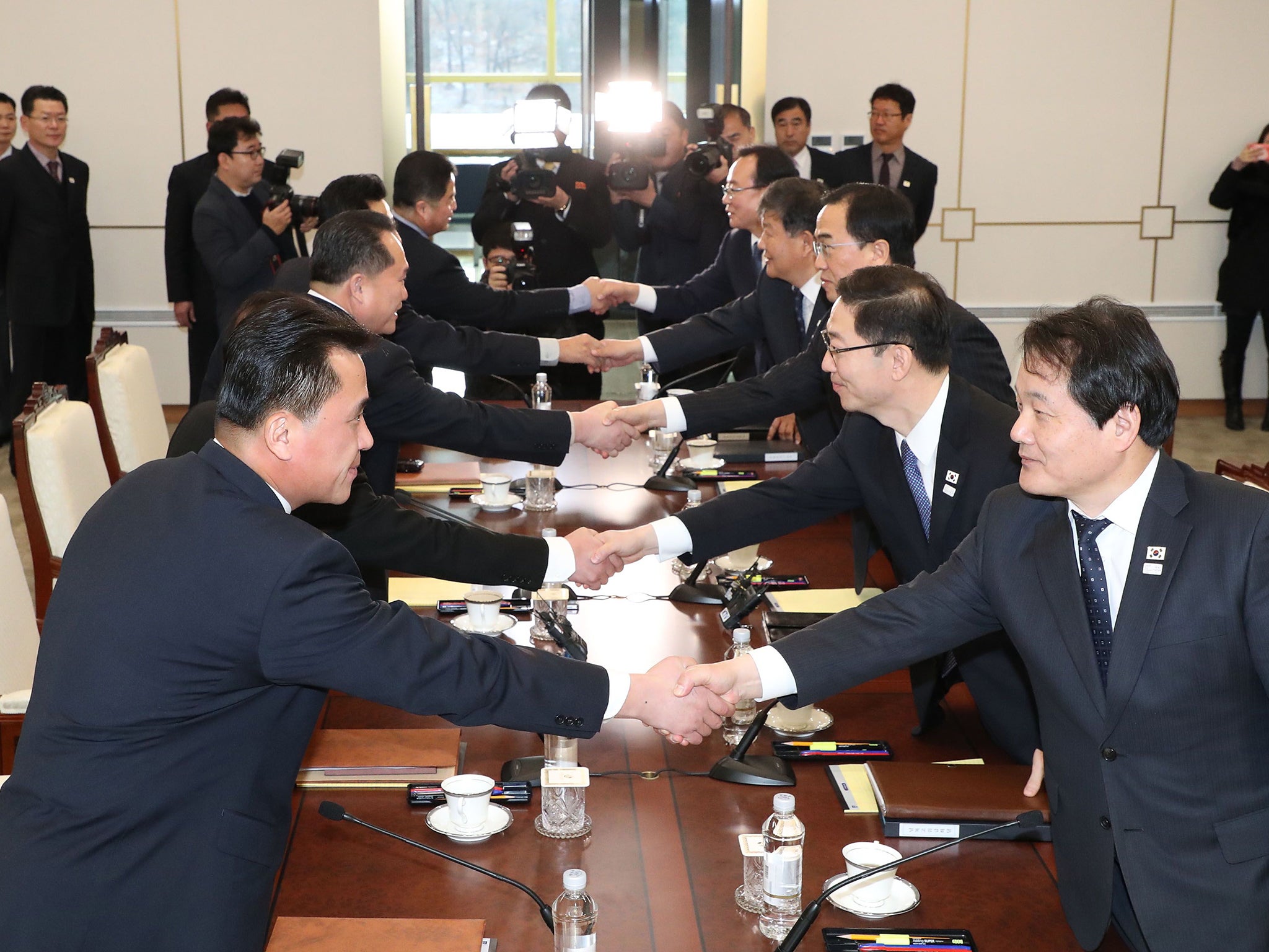 Members of the South Korea Delegation (R) shake hands with members of the North Korea delegation during their meeting at the border truce village of Panmunjom