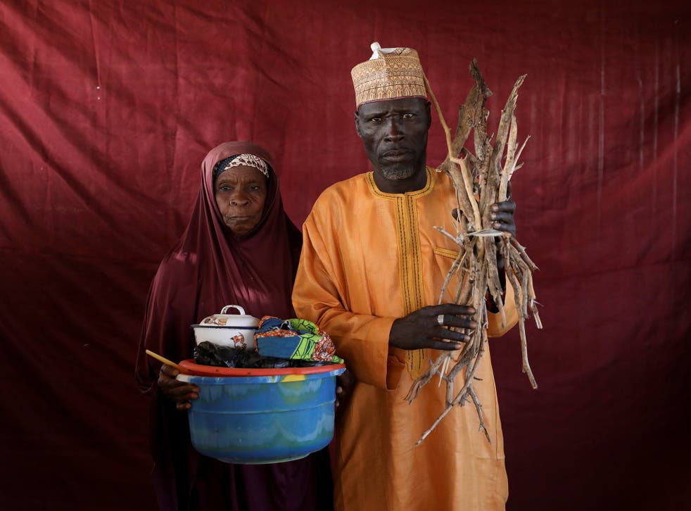Aisha Umaru presents a basin of milk as Umari Usman Kaski holds up firewood