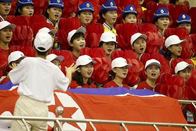North Korean official cheerleaders sing prior to the start of the women’s weight lifting final at the 14th Asian Games in 2002