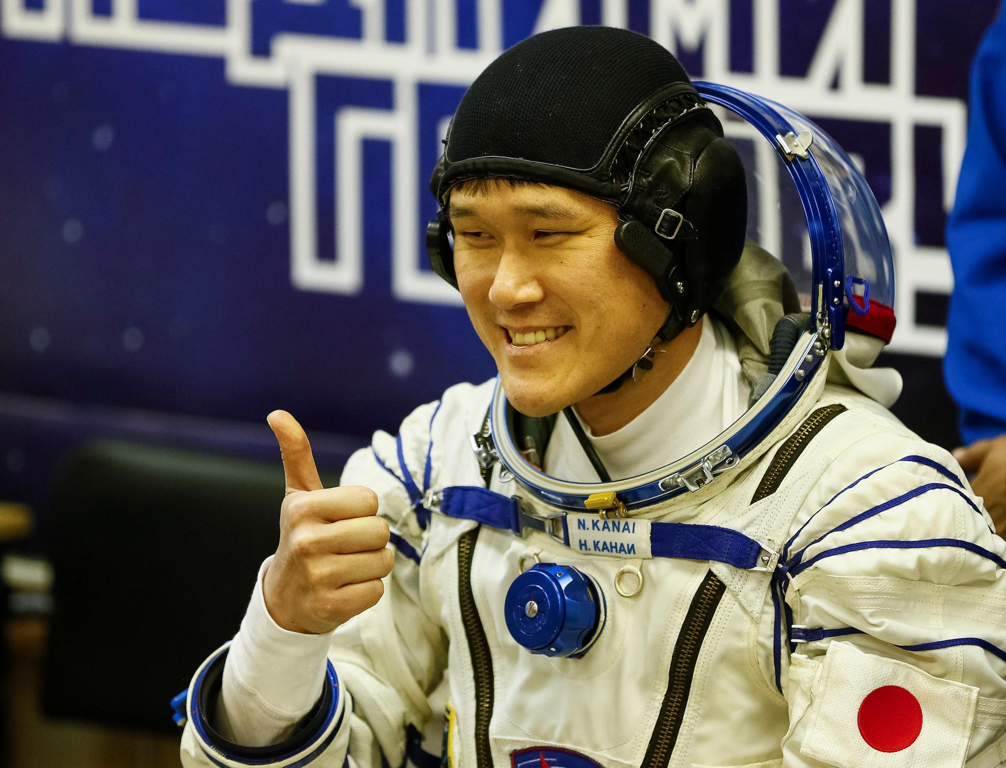 ISS crew member Norishige Kanai of Japan waves during his space suit check