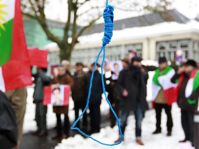 Iranian exiles shout slogans in front of a mock gallows during a demonstration in Brussels in 2010