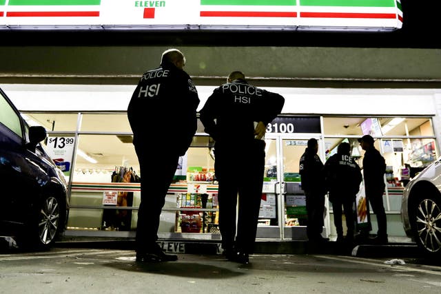 US Immigration and Customs Enforcement agents serve an employment audit notice at a 7-Eleven in Los Angeles