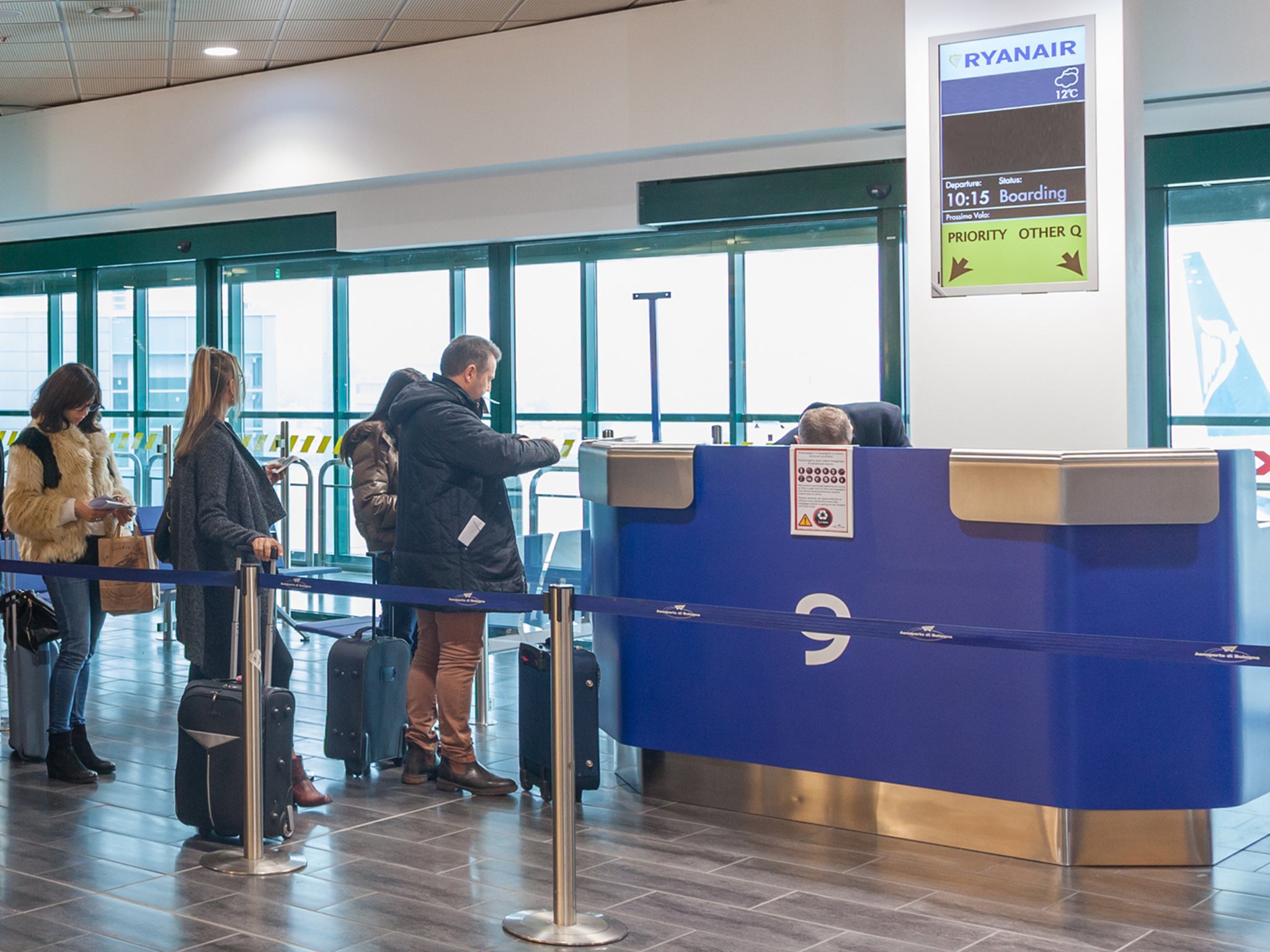 Passengers at a Ryanair check-in counter