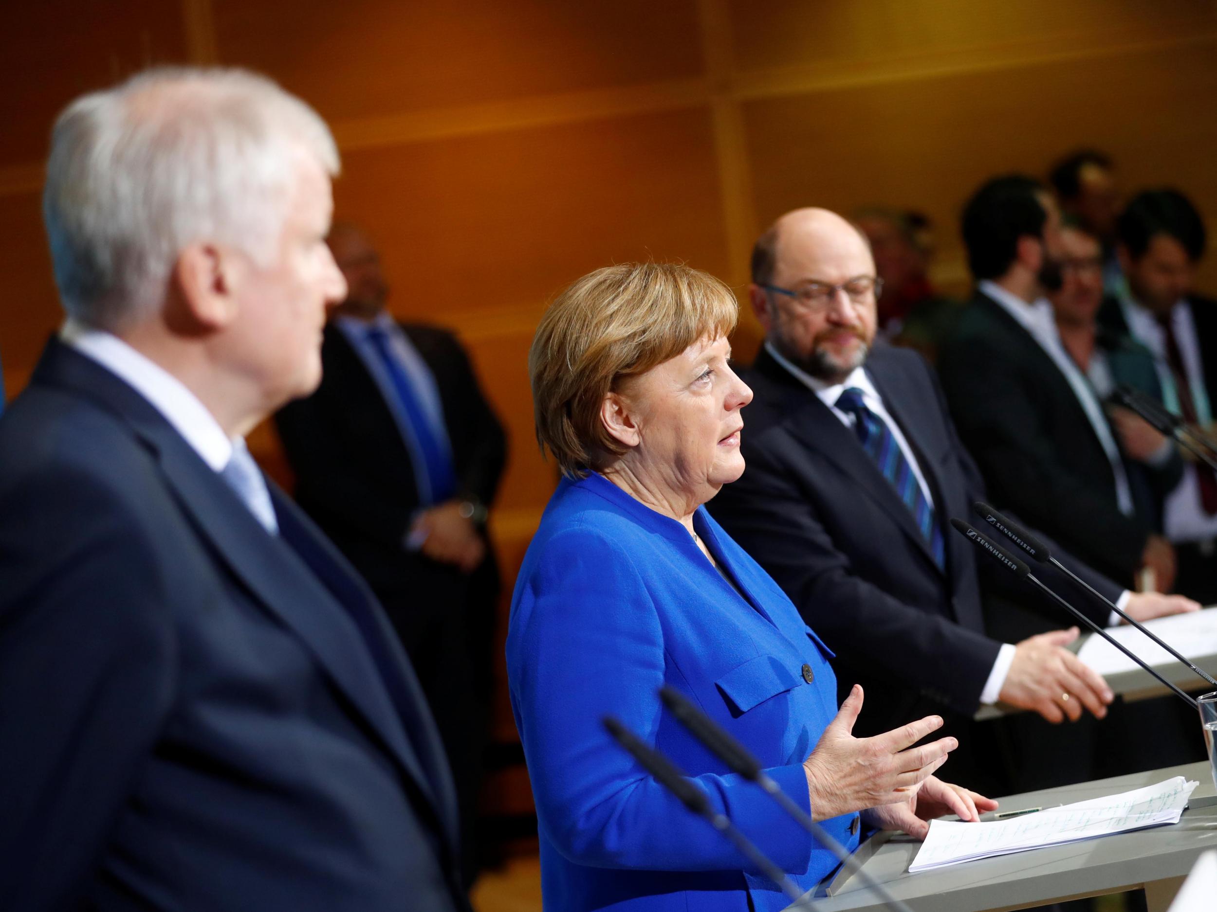 Acting German Chancellor Angela Merkel, leader of the Christian Social Union in Bavaria Horst Seehofer and Social Democratic Party leader Martin Schulz attend a news conference after exploratory talks about forming a new coalition government at the SPD headquarters in Berlin