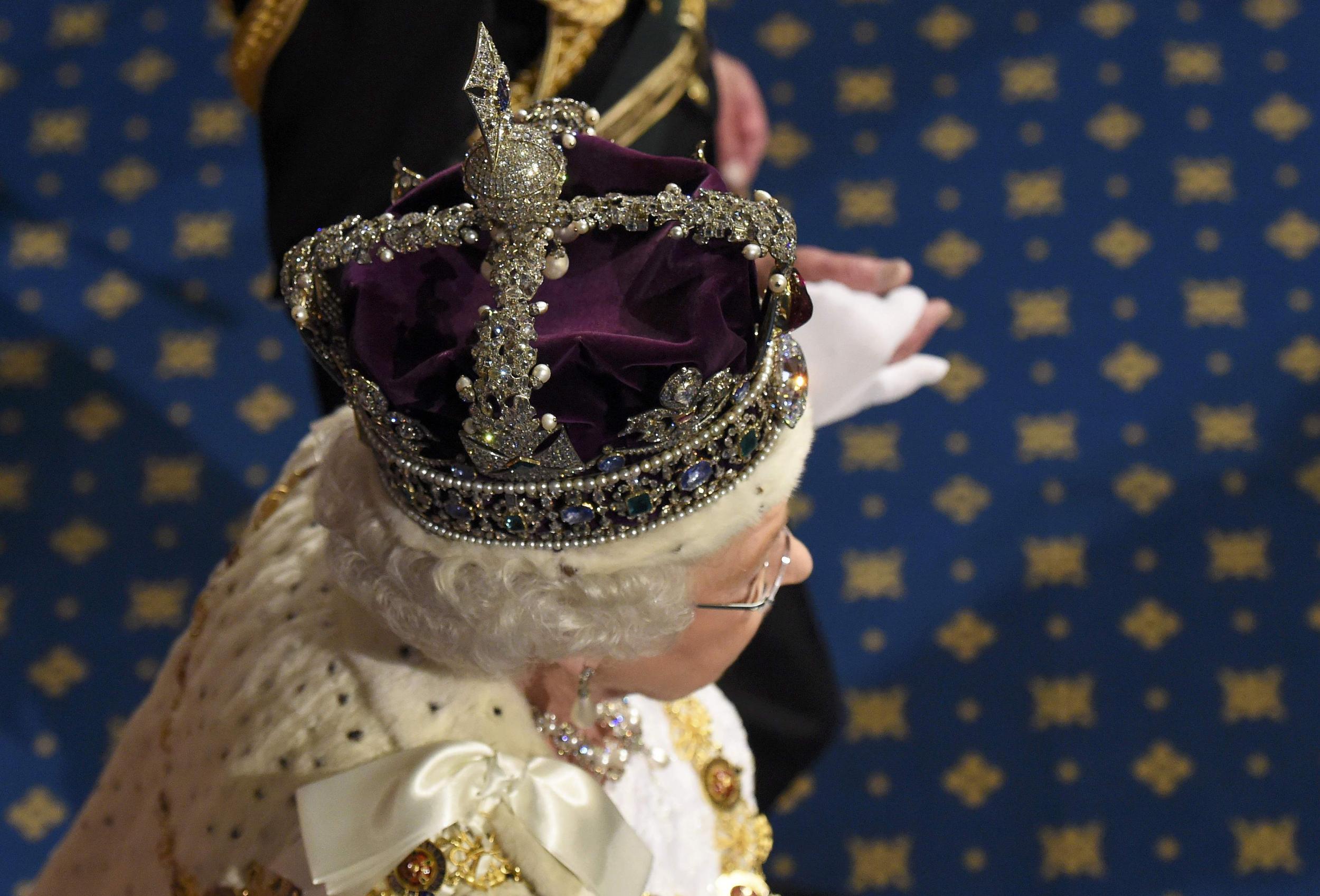 Queen Elizabeth II wears the crown as she proceeds through the Royal Gallery after the state opening of parliament in May 2016