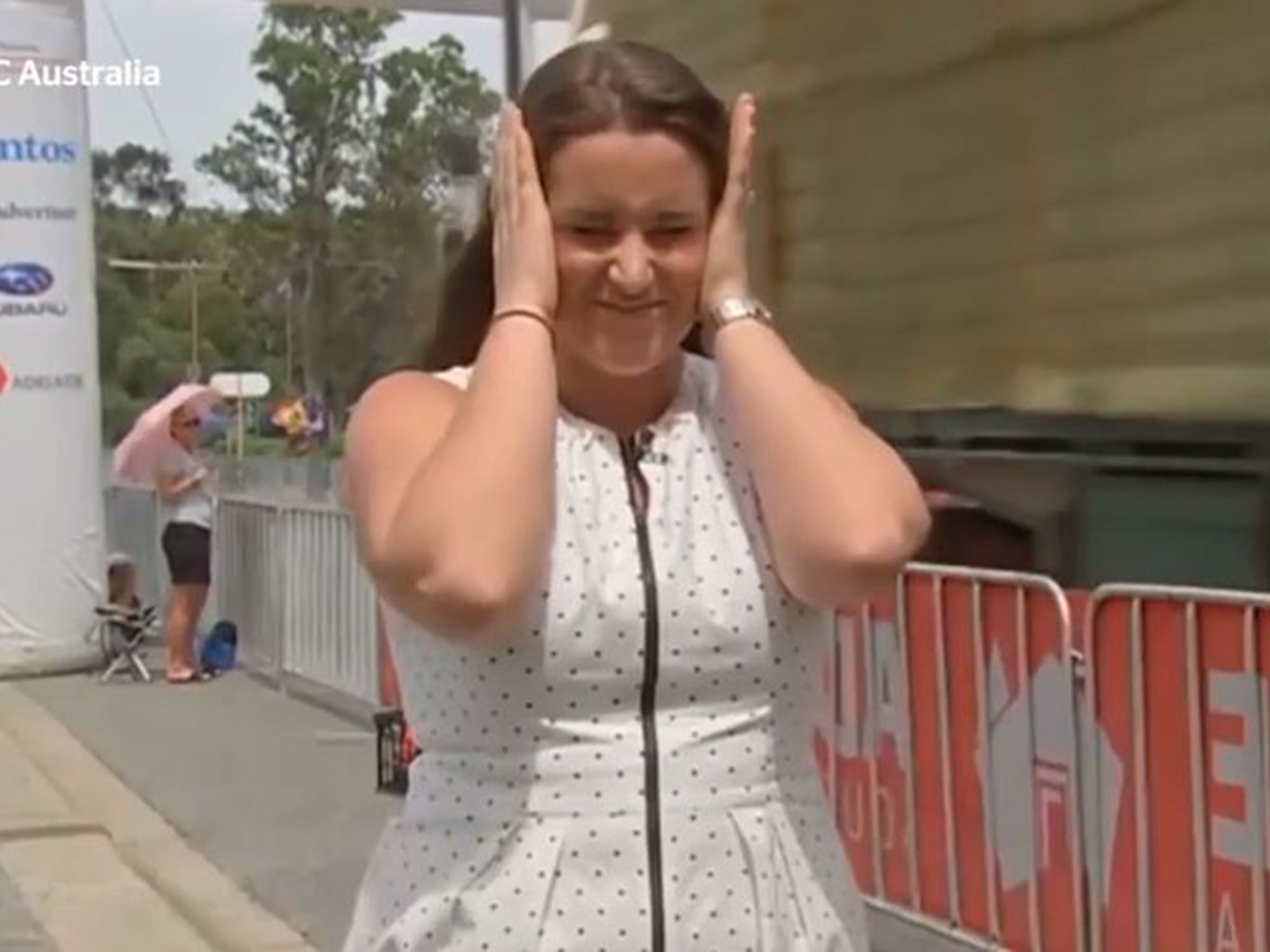 Reporter Sarah Hancock covers her ears as the truck heads towards the finish line