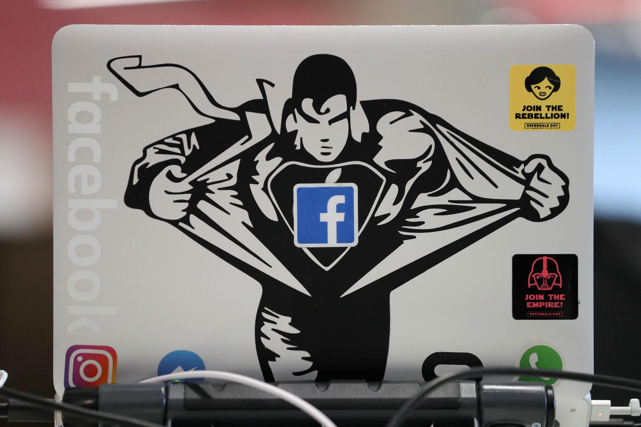 A Facebook sticker is pictured on a laptop at Facebook's new headquarters, designed by Canadian-born American architect Frank Gehry, at Rathbone Place in central London on December 4, 2017