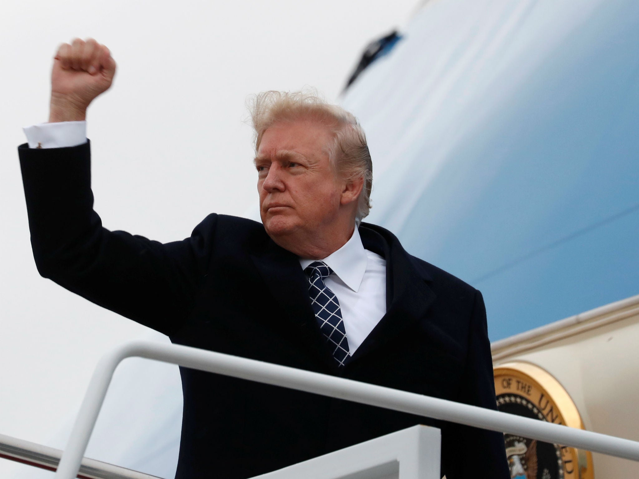 Donald Trump pumps his fist as he boards Air Force One upon departure from Joint Base Andrews