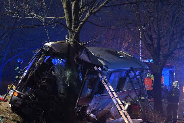 Rescue workers and firemen work at a bus after its collision with a car at Horomerice near Prague