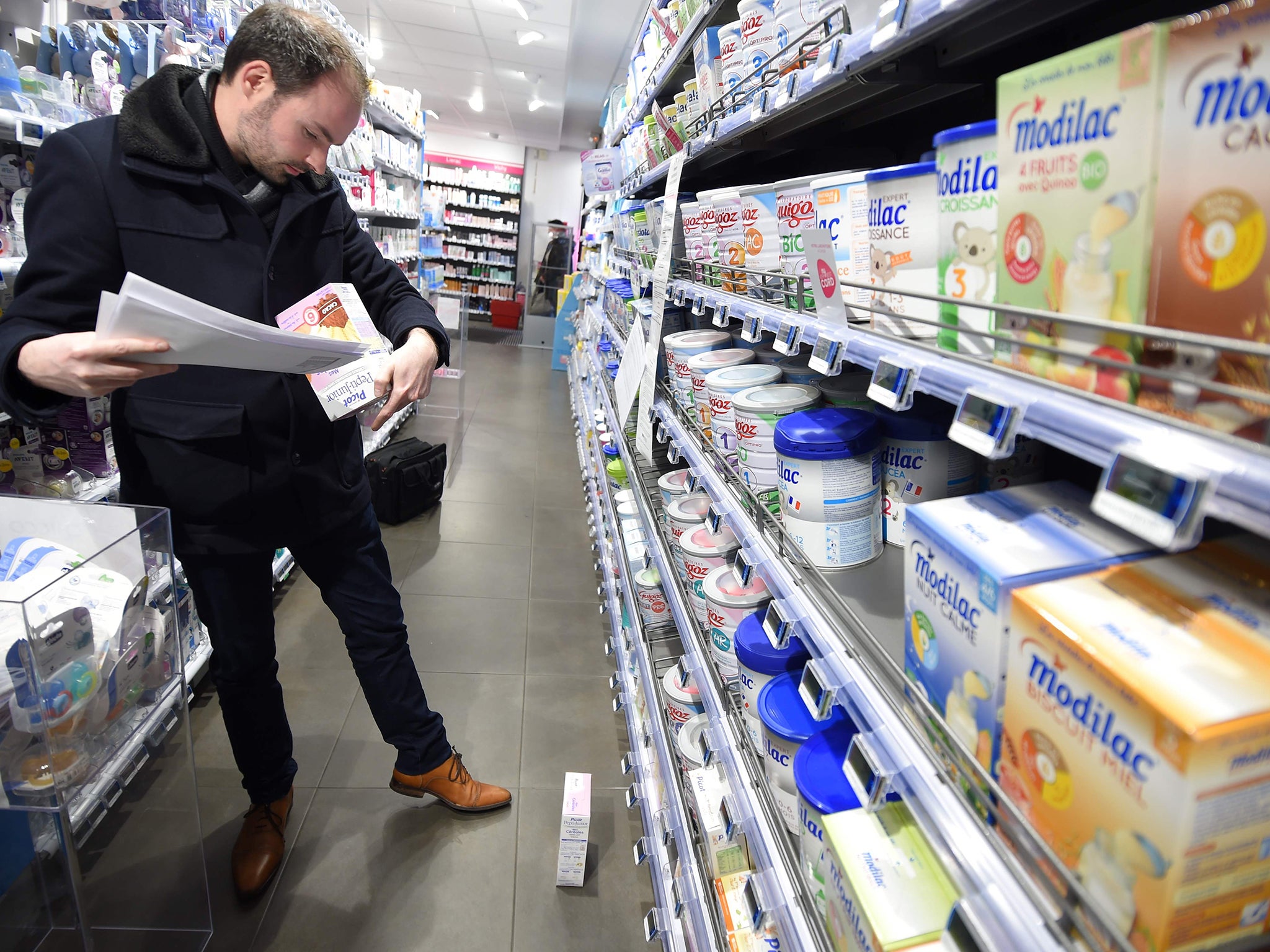 A member of French General Directorate of Competition, Policy Consumer Affairs, and Fraud Control (DGCCRF) checks baby milk products in a pharmacy in Orleans. More than 12 million boxes of powdered baby milk distributed by diary company Lactalis have now been recalled in a salmonella scandal.