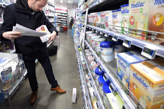 A member of French General Directorate of Competition, Policy Consumer Affairs, and Fraud Control (DGCCRF) checks baby milk products in a pharmacy in Orleans. More than 12 million boxes of powdered baby milk distributed by diary company Lactalis have now been recalled in a salmonella scandal.