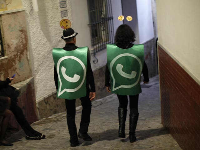 Revellers dressed up as dancers of 'Black Swan' check their mobile phones next to revellers dressed up as a Whatsapp logo as they take part in New Year's celebrations in Coin, near Malaga, southern Spain, early January 1, 2015