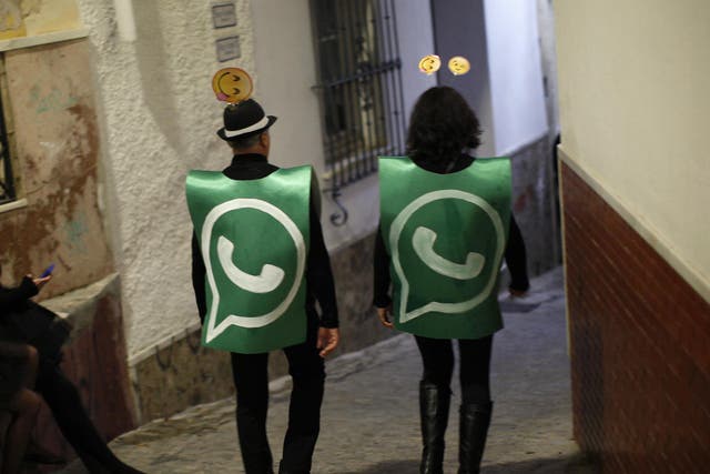 Revellers dressed up as dancers of 'Black Swan' check their mobile phones next to revellers dressed up as a Whatsapp logo as they take part in New Year's celebrations in Coin, near Malaga, southern Spain, early January 1, 2015