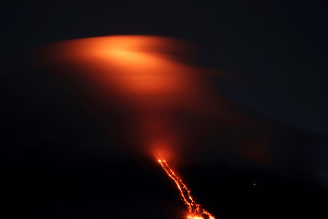 The reddish glow of lava drifting from Mayon volcano