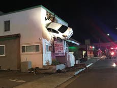 Speeding car flies into air and crashes into top floor of building