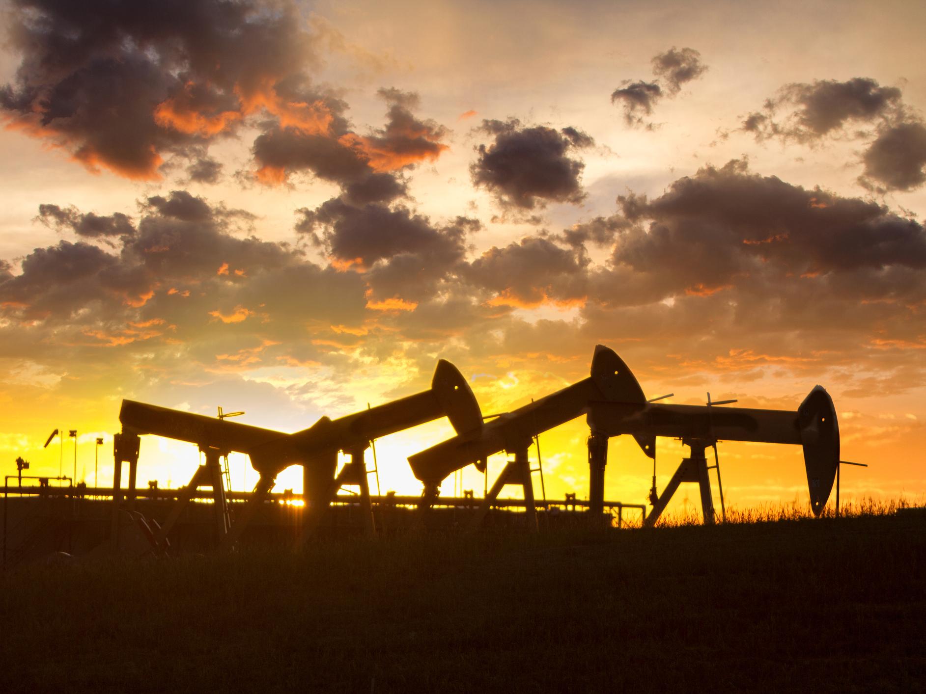 Fracking Drill Rig in a remote location on the prairie in a hay field with bales