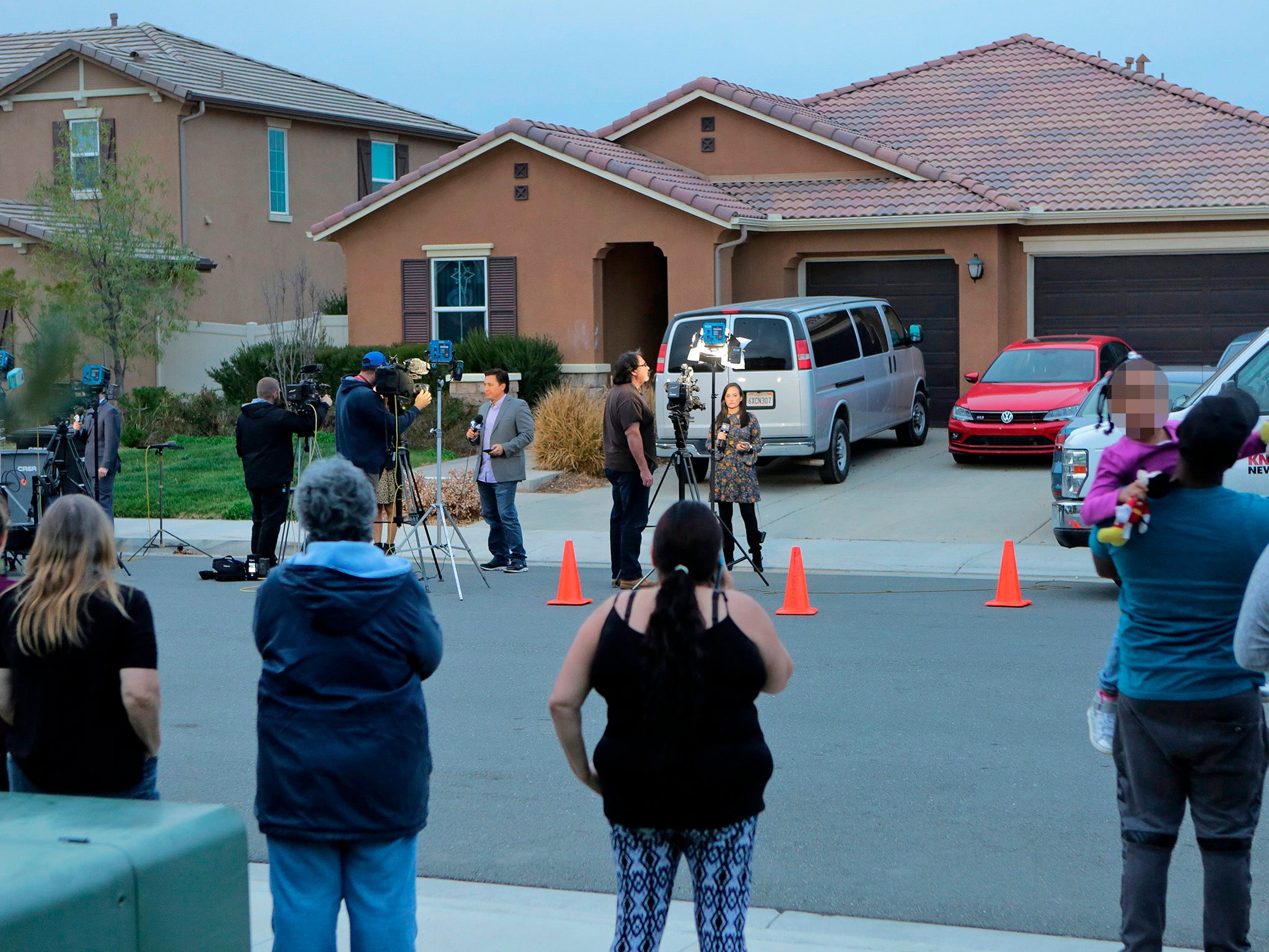 Perris residents watch as media gather in front of the Turpin's house