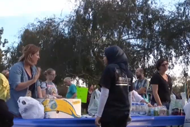 Volunteers offer out food in a park in San Diego