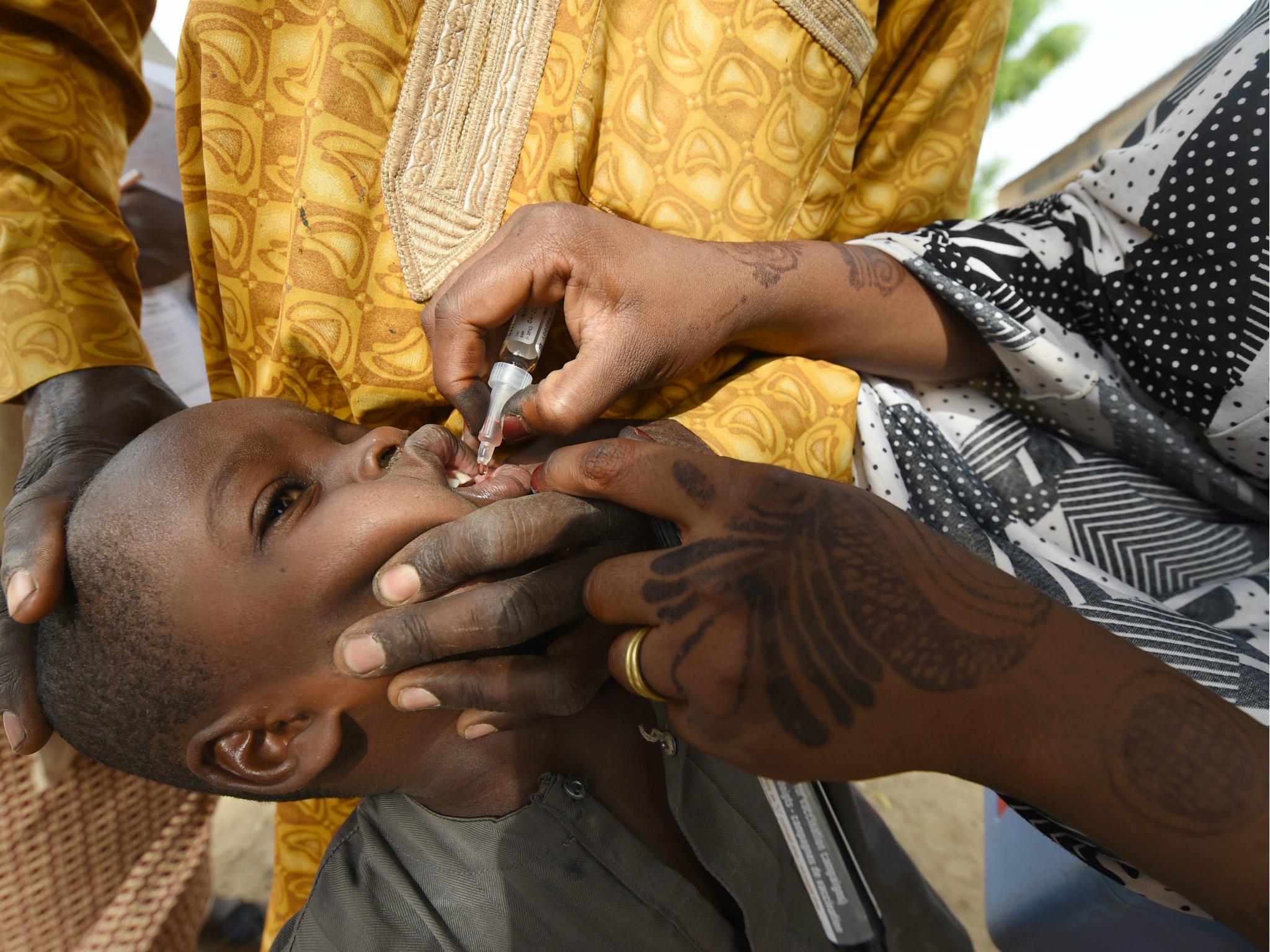 Health worker tries to immunise a child during a vaccination campaign against polio in northwest Nigeria on 22 April 2017.
