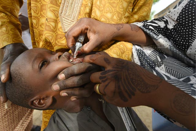 Health worker tries to immunise a child during a vaccination campaign against polio in northwest Nigeria on 22 April 2017.