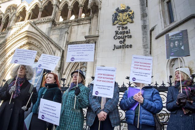 Women protest outside the High Court as a groundbreaking case is underway to expunge the records of teenagers who were pimped and prostituted