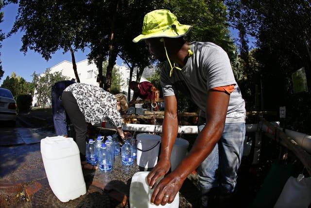 Residents of Cape Town collect drinking water from a mountain spring collection point in the city
