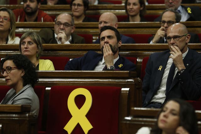 Yellow ribbons marked the seats of Catalan parliamentarians who could not attend the opening session because they are in jail in Madrid