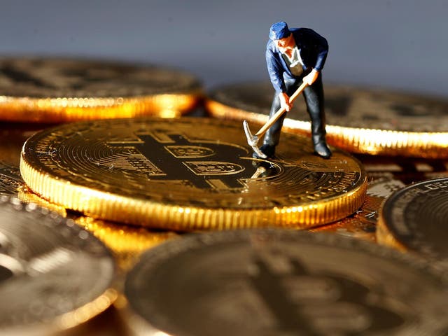 A small toy figure is seen on representations of the Bitcoin virtual currency in this illustration picture, December 26, 2017