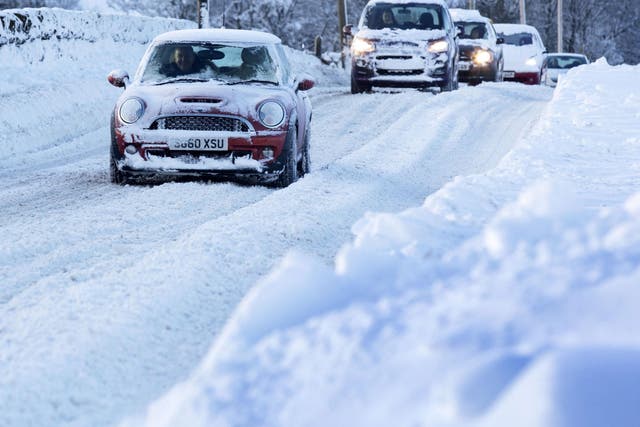 Vehicles make their way through heavy snow in Midlothian near Edinburgh