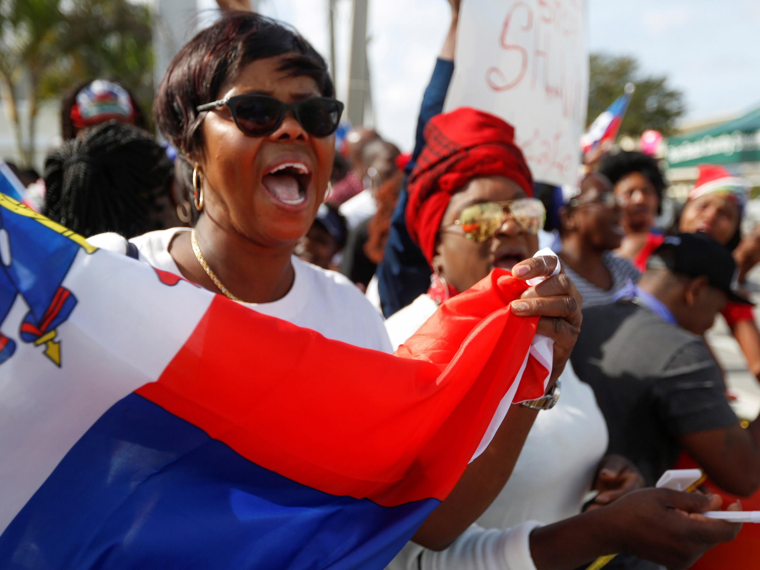 People protest against US President Donald Trump's recent comments and tough stand on immigration near the Southern Boulevard bridge to Palm Beach near Mar-a-Lago, Florida