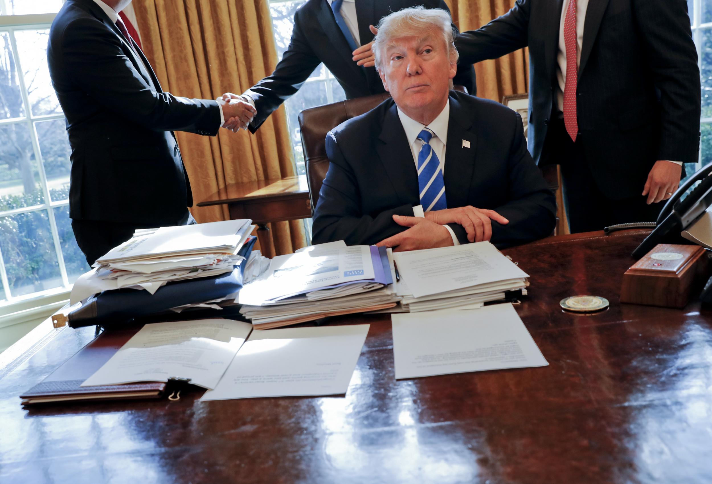 Cutting a lonely figure: the President at his desk in the Oval Office