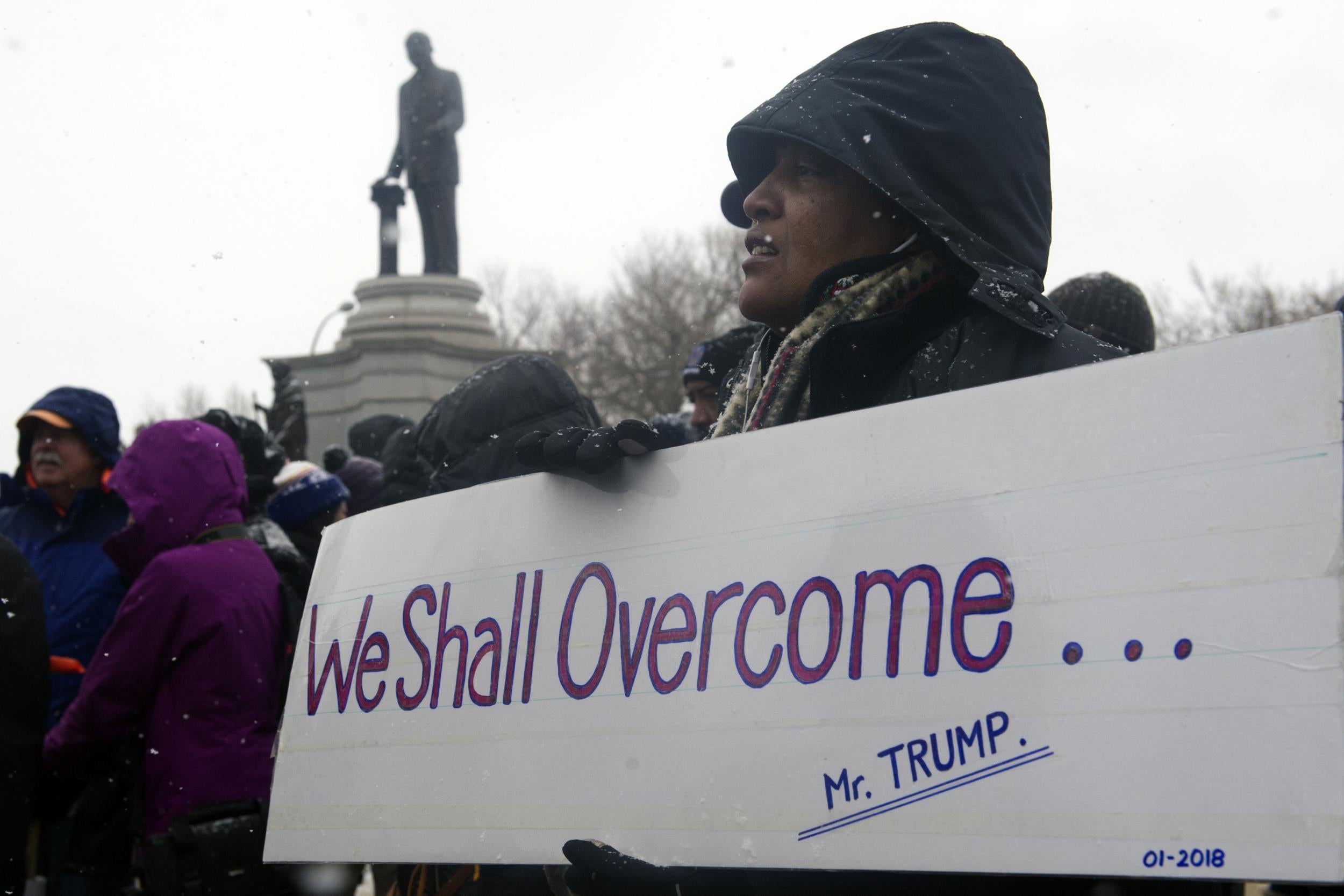 Lesa Webb of Los Angeles, California, holds up a sign before marching in the 32nd Annual Martin Luther King, Jr march and parade in Denver, Colorado