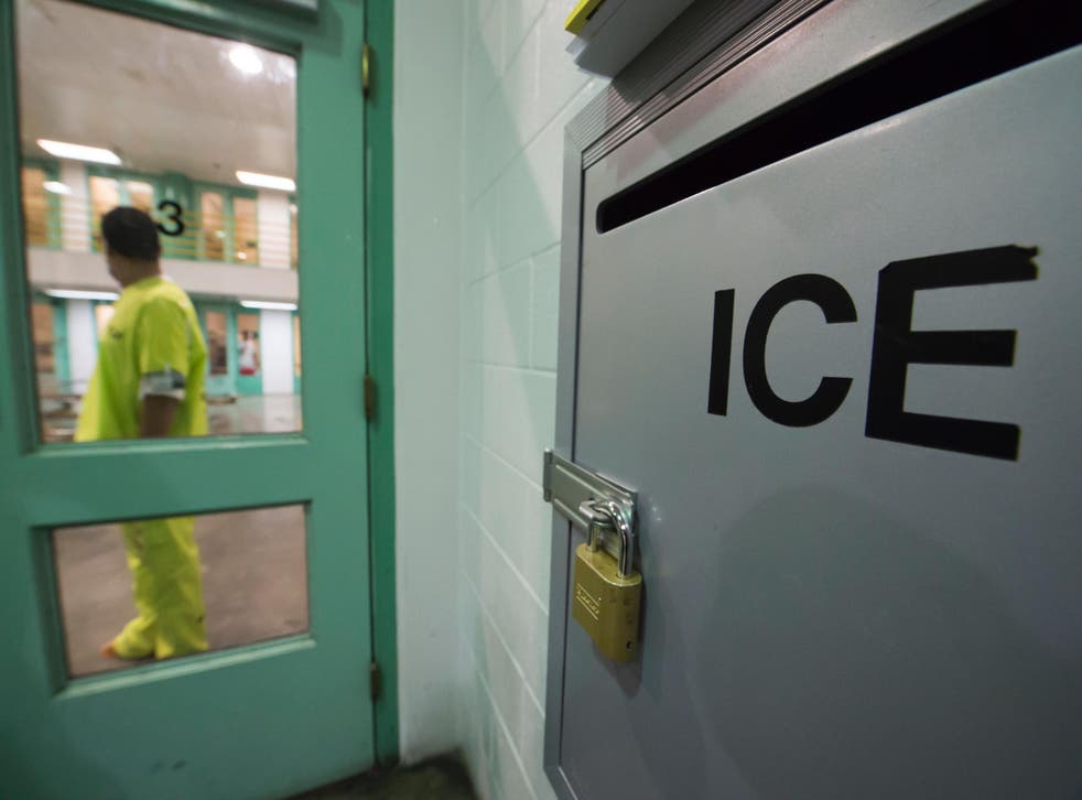 An immigration detainee stands near an US Immigration and Customs Enforcement (ICE) grievance box at an unrelated facility