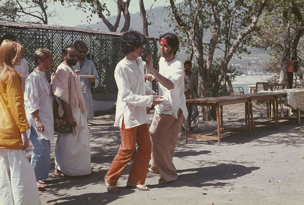 Paul McCartney dabs red paint on Scottish singer Donovan at the compound in 1968