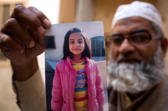 Zainab Ansari's father Mohammed Amin holds up a picture of his daughter