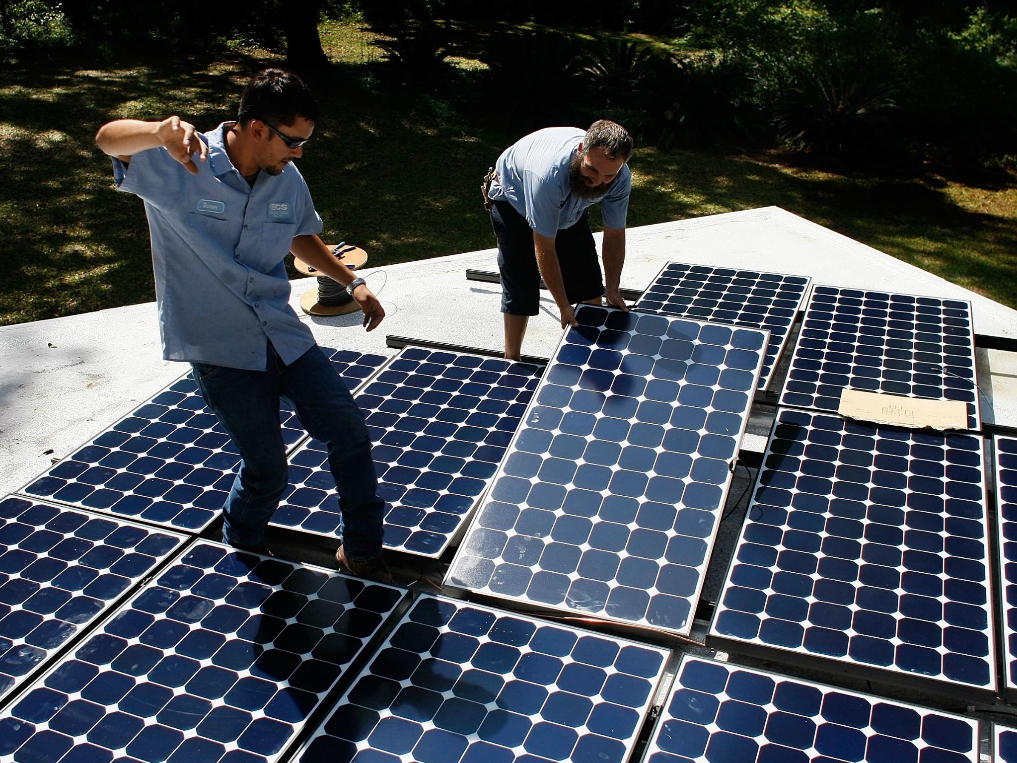 Workers install a solar panel system on the roof of a home in Gainesville, Florida.