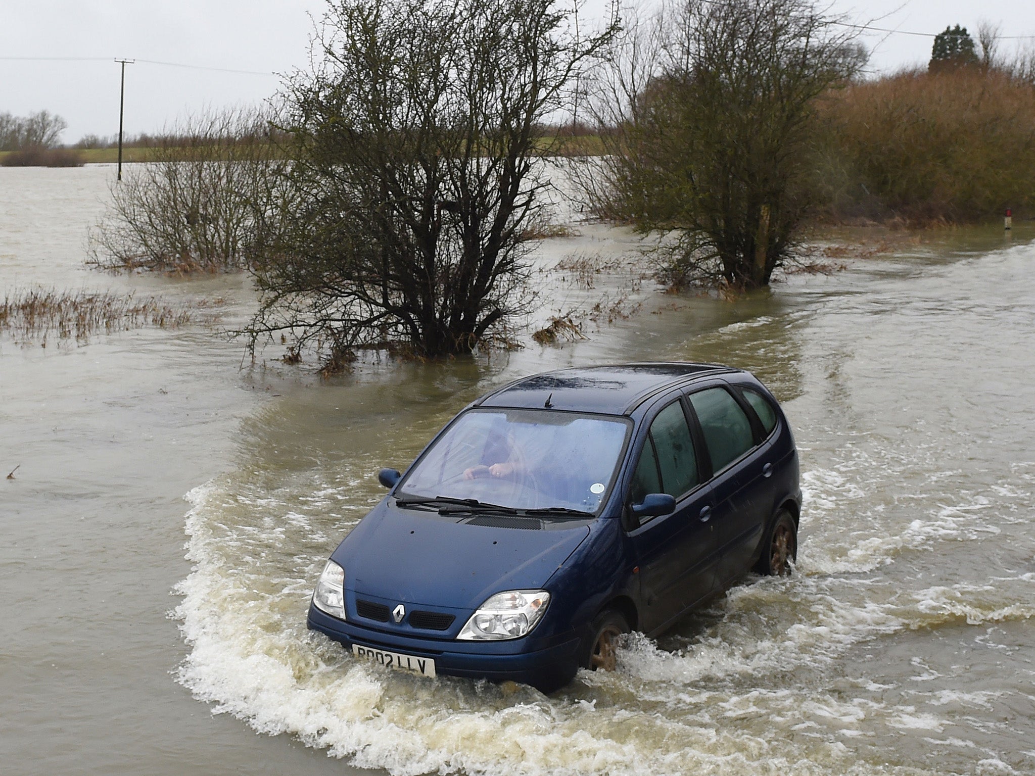 A car driving down a flooded road near Sutton in Cambridgeshire, as parts of Britain are battered with strong winds and heavy rain from Storm Georgina
