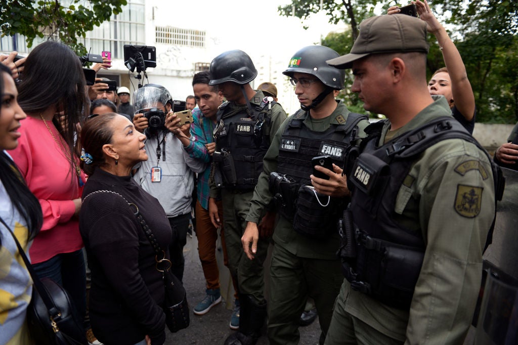Aura Perez (left) aunt of the dead rebel, speaks with a member of the national guard outside the morgue in Caracas