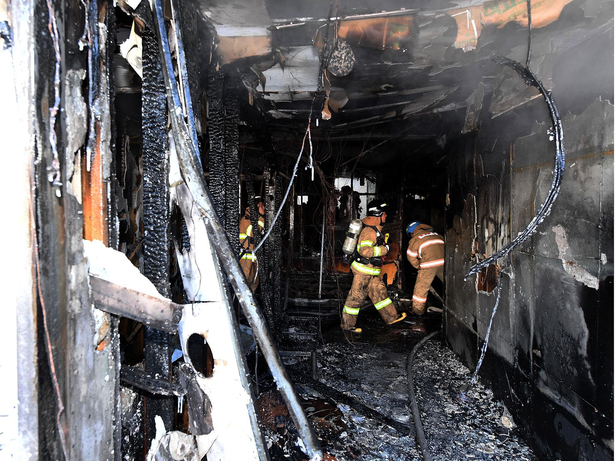 Firefighter inspects the burnt remains of the hospital in Miryang, South Korea