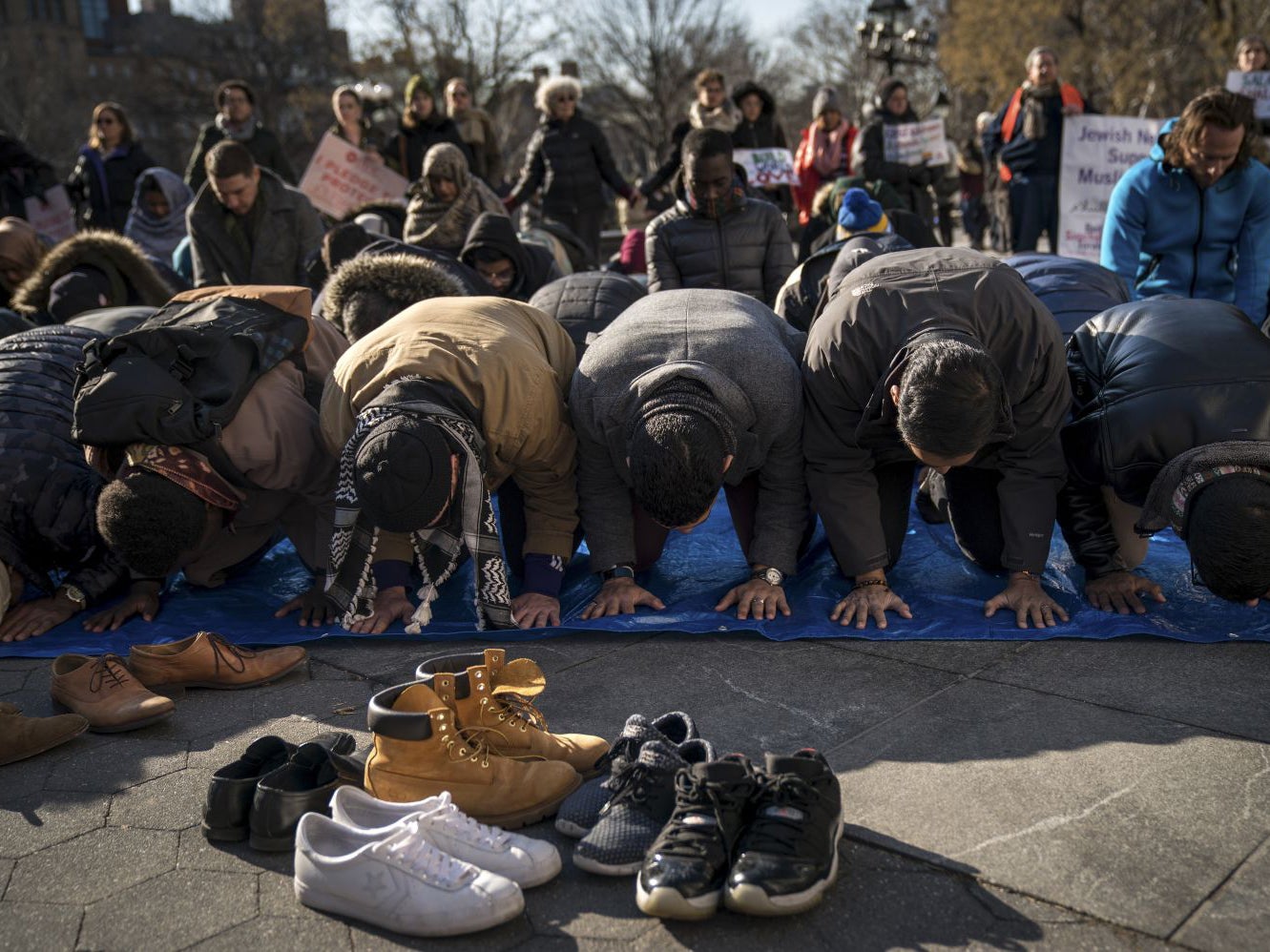 Muslims pray following a protest to the mark the one year anniversary of the Trump administration's executive order banning travel into the United States from several Muslim majority countries, in Washington Square Park, 26 January, 2018 in New York City. After numerous legal challenges, the travel ban is now in its third iteration. The Supreme Court is scheduled to hear the 'Trump v Hawaii' case concerning the travel ban this spring