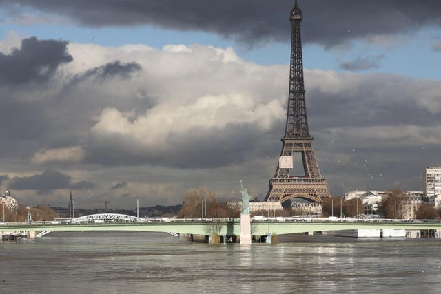 A picture taken on 26 January 2018, shows the flooded Ile aux Cygnes and banks of the river Seine with a model of the Statue of Liberty and the Eiffel Tower in the background in Paris